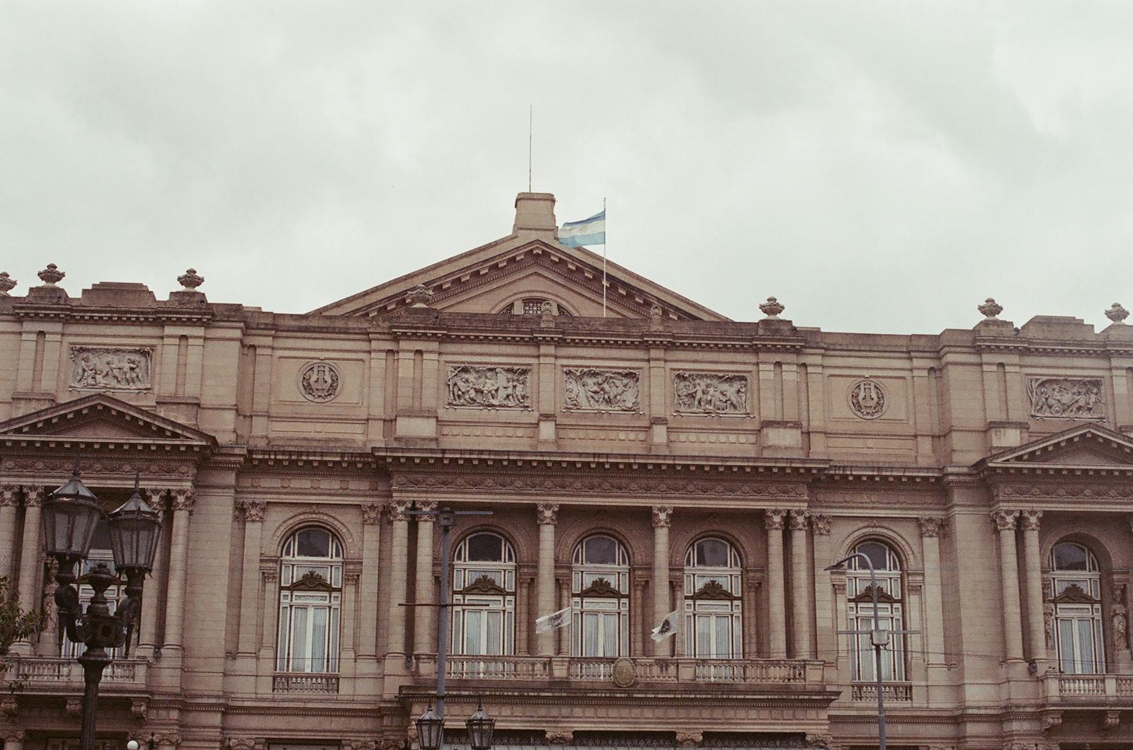 Front view of the neoclassical Teatro Colón facade with intricate sculptures.